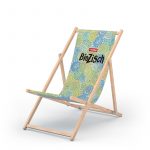Liegestuhl aus Holz mit Liegefläche mit einem grün-blauen Schneckenmuster und mittigem Aufdruck "BioZisch" in schwarz und rot-weißem voelkel-Logo darüber