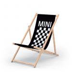 Liegestuhl aus Holz mit schwarzer Liegefläche, einem weiß-schwarzen Schachbrettmuster und Aufdruck "Mini"